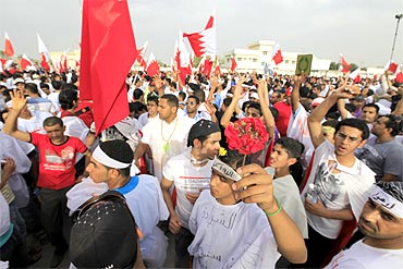 Anti-government protesters shout slogans at the gate of Bahrain King's al-Safriya Palace in Zallaq