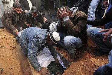 A man buries a rebel killed by forces loyal to Libyan leader Muammar Gaddafi in Ajdabiya