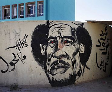 Revolutionary graffiti caricaturing Muammar Gaddafi adorns a wall in Benghazi