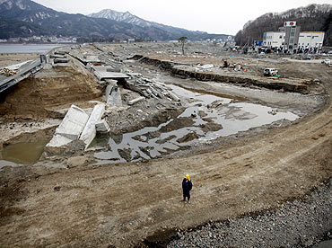 A man stands next to the damaged seawall of Miyako town, Iwate Prefecture