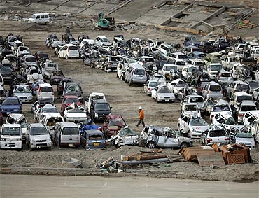 Vehicles destroyed by the earthquake and tsunami are seen at a car dump in Miyako town, Iwate prefecture