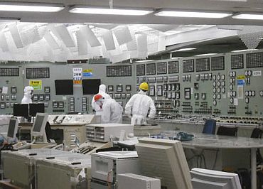 People work in the control room of reactor No 2 with restored lighting