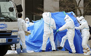Japan Self Defense Force members in protective clothing prepare to transfer to another hospital workers who were exposed to radiation