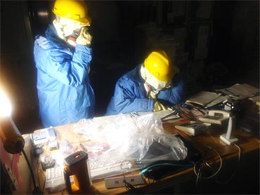 Handout photo from the Japan's Nuclear and Industrial Safety Agency shows Tokyo Electric Power Co. workers recording the status of instruments in a control room at the Fukushima Daiichi Nuclear Power Plant