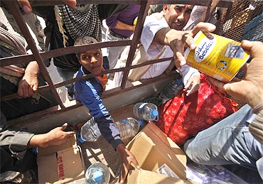 Libyans gather to receive food bring distributed by a local resident in Ajdabiyah on Sunday