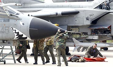 Italian ground crew work on a Tornado jet fighter plane. NATO ambassadors approved an operations plan for the alliance to help enforce a UN arms embargo on Libya on Sunday, a NATO statement said