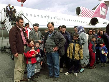 Albanian refugees waits in a queue after they disembark from a plane at Berlin's Schoenefeld airport