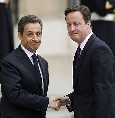 France's President Nicolas Sarkozy greets Britain's Prime Minister David Cameron at the Elysee Palace ahead of wider international talks on Libya in Paris
