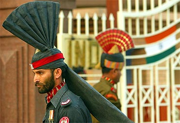 A Pakistani Patan guard and an Indian Border Security force officer march during a ceremony