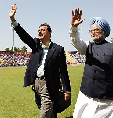 Gilani and PM Manmohan Singh wave to spectators prior to the start of the 2011 ICC World Cup second Semi-Final between India and Pakistan at Mohali