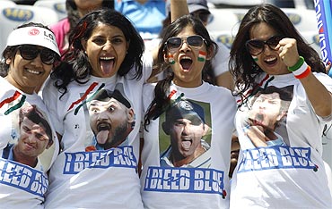 Fans of India pose wearing T-shirts with the faces of Indian players before the start of the match at Mohali