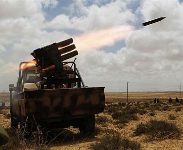 Rebels fire rockets as they return fire towards forces loyal to Muammar Gaddafi near Brega in eastern Libya