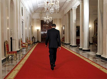 US President Barack Obama walks down the Cross Hall of the White House