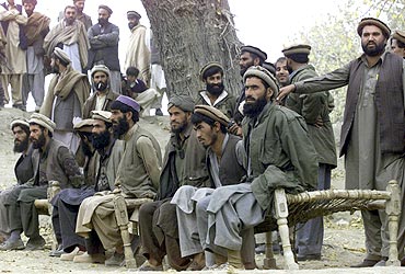 Captured Afghan Al Qaeda members sit on a bench as they are presented to the media in Tora Bora, in this file picture taken on December 17, 2001
