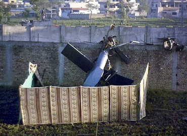 Part of a damaged helicopter is seen lying near Osama's compound