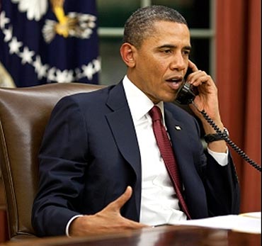 Obama talks on the phone in the Oval Office before making a statement to the media about the mission against bin Laden
