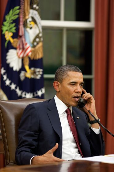 President Barack Obama talks on the phone in the Oval Office before making a statement to the media about the mission against Osama bin Laden