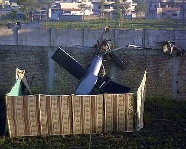 Part of a damaged helicopter is seen lying near the compound where Al Qaeda leader Osama bin Laden was killed