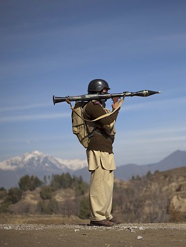 Pakistani soldier Hamed holds a rocket launcher while securing a road in Damadola, located in Bajaur