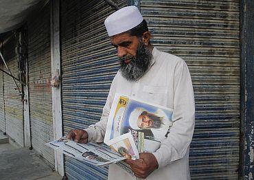 A man reads a local newspaper reporting the death of al-Qaeda leader Osama bin Laden in Abbottabad