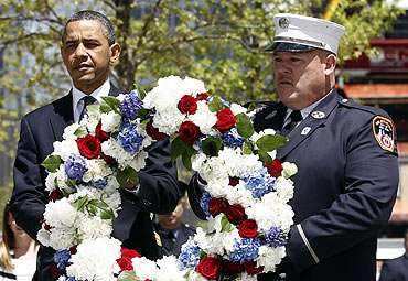 President Obama carries a wreath accompanied by a New York City firefighter at the Ground Zero site of the World Trade Center in New York