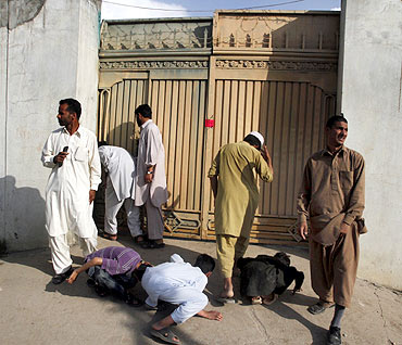 Local residents try to look past the gates into the compound where Osama bin Laden was killed in Abbottabad