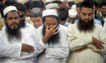 Supporters of the banned Jamaat-ud-Dawa weep while taking part in a symbolic funeral prayer for Osama bin Laden in Karachi