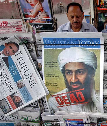A roadside vendor sells newspapers with headlines about the death of Osama bin Laden in Lahore