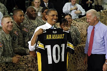 President Obama holds up a shirt for the 101 Airborne after speaking to troops at Fort Campbell in Kentucky