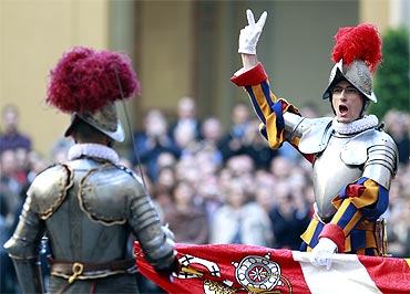A  new recruit of the Vatican's elite Swiss Guard gestures during the swearing in ceremony at the Vatican