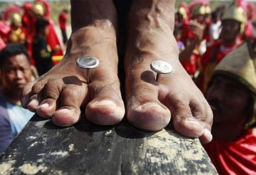Three-inch custom made stainless steel nails pierce the feet of a penitent crucified during the Good Friday lenten rites in San Juan, San Fernando city, Pampanga province in northern Philippines April 22