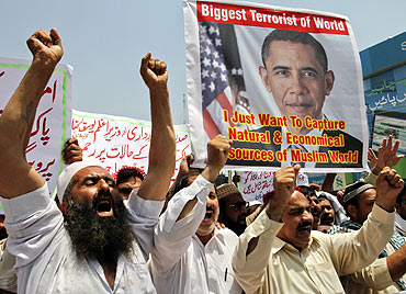 People shout anti-American slogans while holding an image of US President Barack Obama during a protest condemning the killing of Osama bin Laden