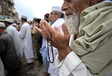 Pakistanis participate in a silent prayer after an anti-American rally in Peshawar