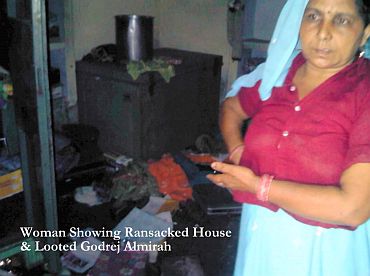 A woman shows her ransacked house