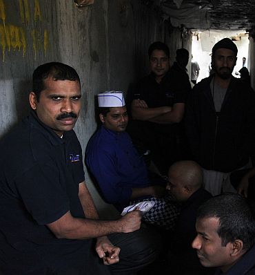 Indian foods service workers stand inside a bunker during a rocket attack by anti-Afghan forces at Forward Operation Base Joyce