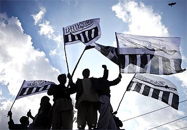 Supporters of Jamaat-ud-Dawa, the frontal outfit for Lashkar-e-Tayiba, hold their party flags