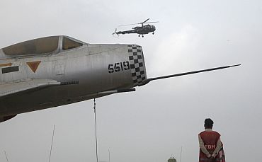Rescue worker watches a military helicopter hover over Mehran naval aviation base, which was attacked by militants, in Karachi
