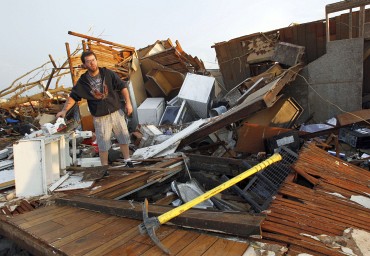 A man sorts through the debris looking for personal belongings after his home was destroyed