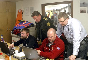 Emergency personnel work at the temporally headquarters at the Geirland farm