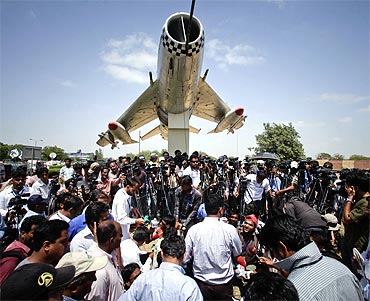 Media personnel gather at the gates of the Mehran naval aviation base after troops ended operations against militants in Karachi