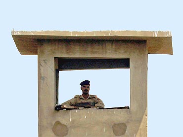 A soldier keeps guard from a watch tower around the compound walls of the Mehran naval aviation base in Karachi