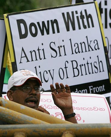 A pro-government supporter shouts behind police barriers outside the British High Commission in Colombo