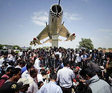Media gather at the gates of the Mehran naval aviation base after troops ended operations against militants in Karachi