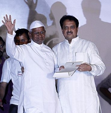 Hazare waves to his supporters after receiving a letter from PM Singh by Union Minister Deshmukh at Ramlila grounds in New Delhi