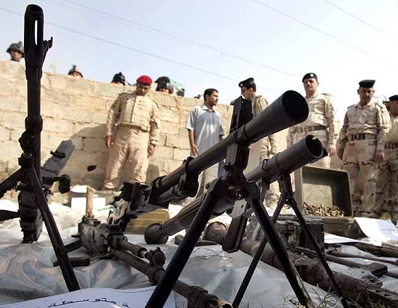 Confiscated weapons and explosive materials are displayed for the media after an army raid on a weapons cache in western Baghdad