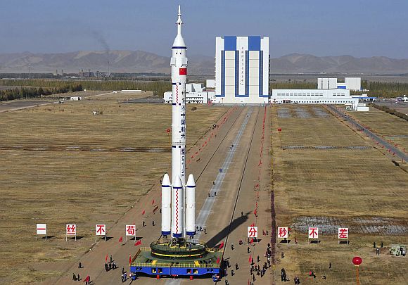Employees transfer the Long March II-F rocket to the launchpad in the Jiuquan Satellite Launch Center