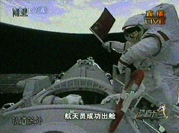 Video grab of astronaut Zhai Zhigang of China waving the national flag after exiting the Shenzhou VII space craft