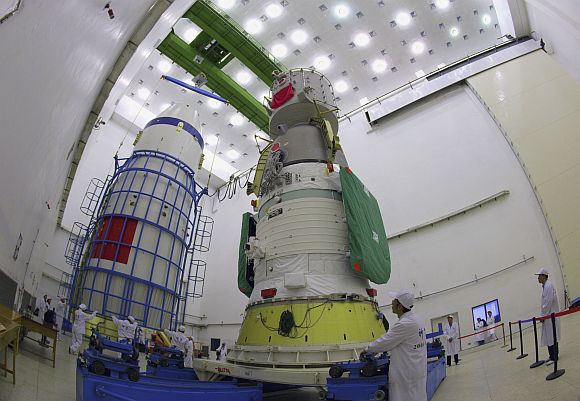 Technicians prepare to assemble the cover of the Shenzhou-7 manned spacecraft at the Jiuquan Satellite Launch Center