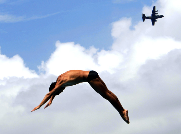 Mexico's Ivan Garcia dives as a C-130 Hercules transport aircraft flies past