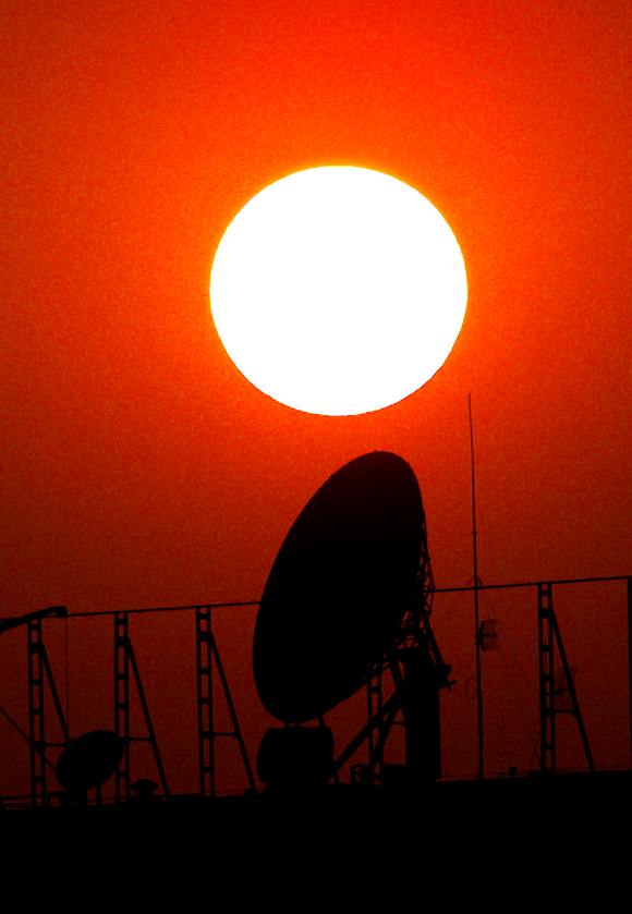 A satellite dish is silhouetted by the setting sun in Beijing.